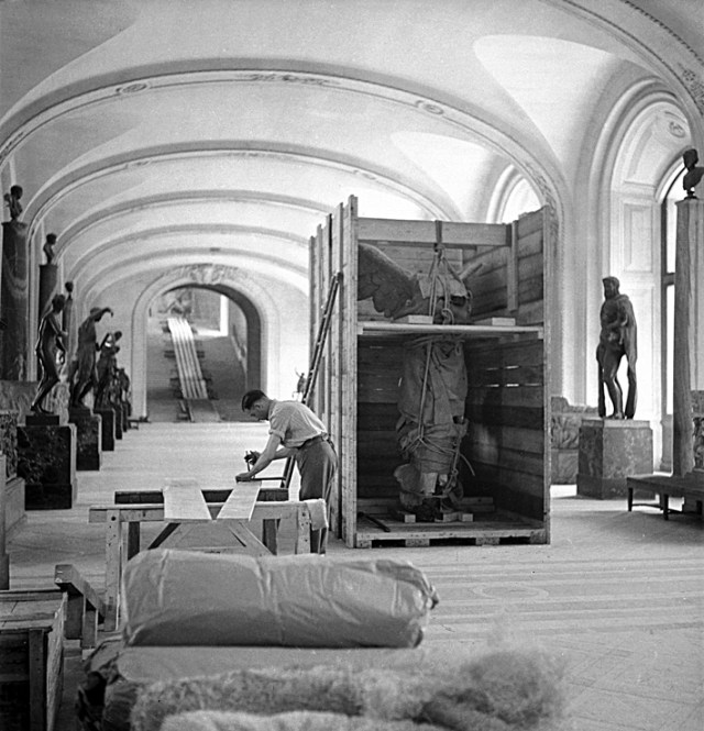 Parijs - De gevleugelde Nike “The Winged Victory of Samothrace was painstakingly removed from her pedestal with a series of ropes and pullies then wheeled out of the museum on a specially installed ramp. One she was packed into a crate, the arduous task of moving her to the French countryside began.” (submitted by yrlisbon-behindthescenes ) (via The Louvre During the War) [This event was documented in candid shots by several photographers, chief among them Pierre Jahan